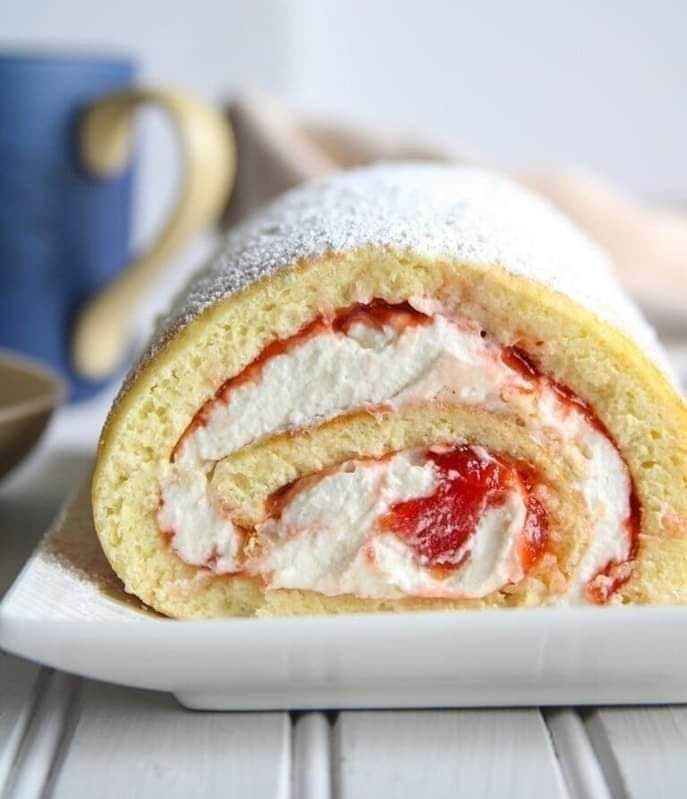 Soft vanilla chiffon rolled and filled with whipped cream and jam